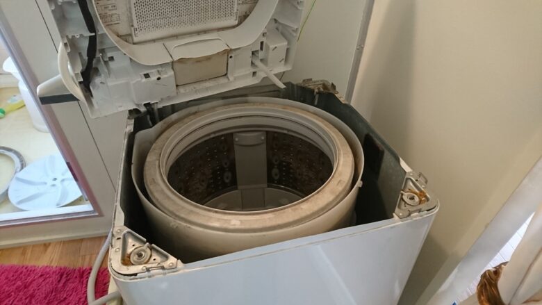 脱水槽を持ち上げる途中、製造年を示すシールが見える