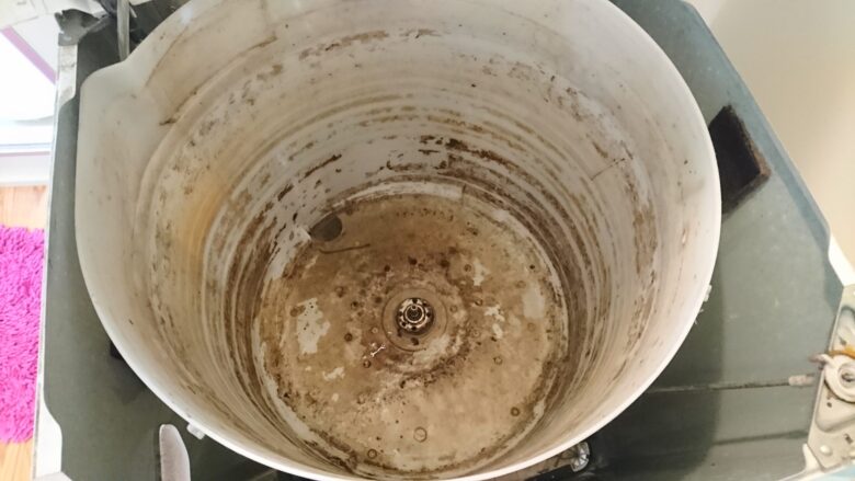 洗濯槽の外側(外槽)内部にこびりついた茶色と黒の汚れ